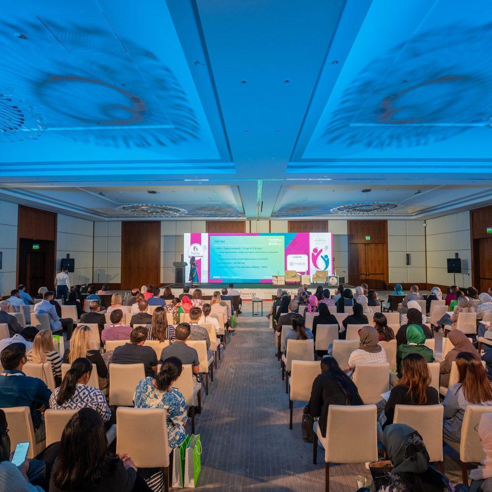 A seated audience listening to a live speaker