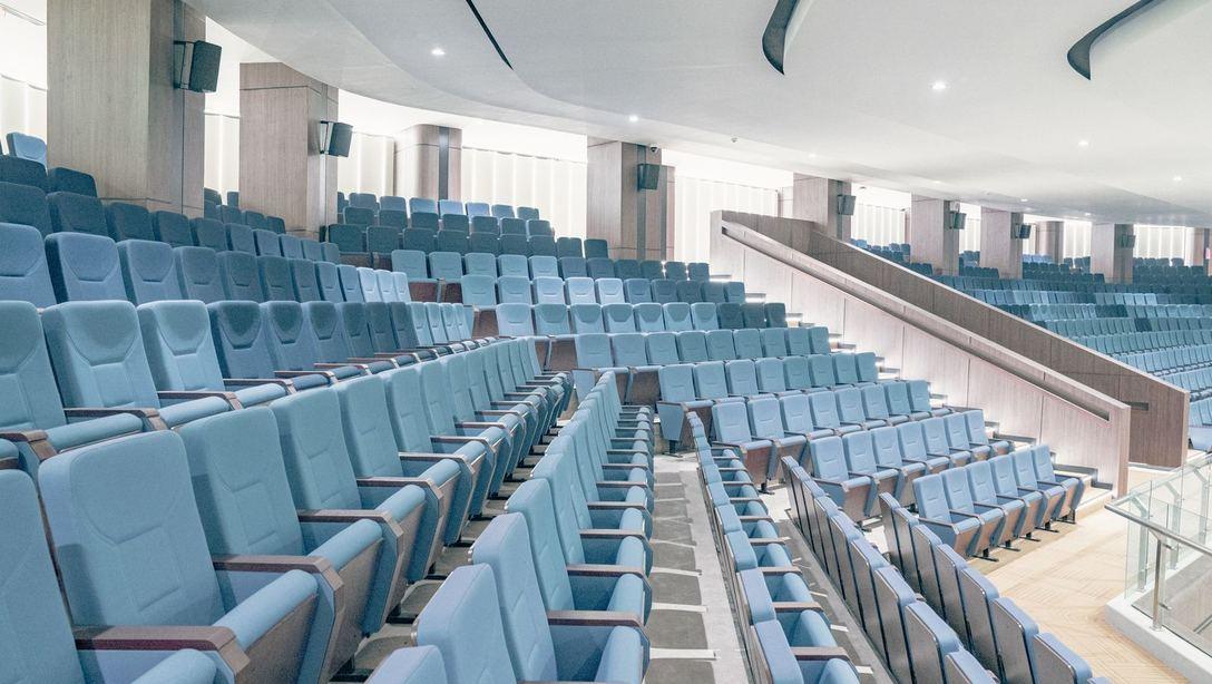 Rows of blue seats in a large gathering space